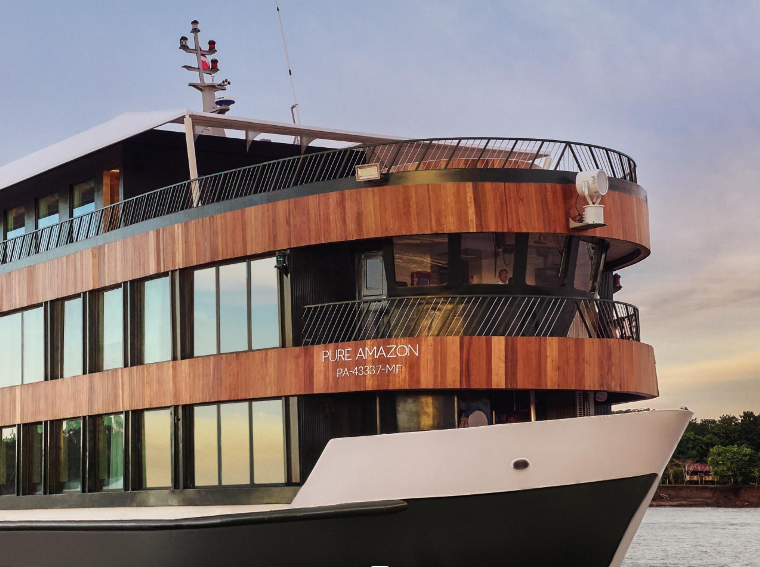The Pure Amazon riverboat on the river at dusk